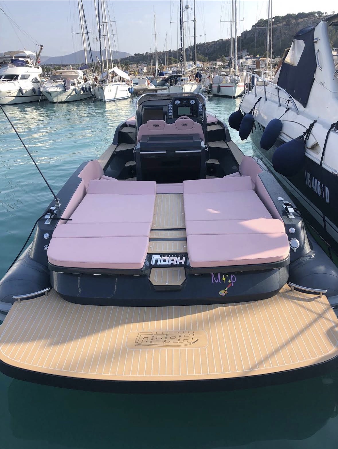 Gommone visto da poppa con prendisole rosa e plancetta in teak